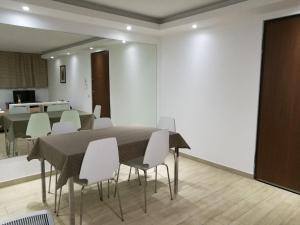 uma sala de jantar com uma mesa e cadeiras brancas em Casa Stefania em Basiglio