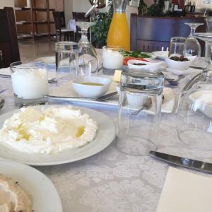 a table with plates of food and candles on it at Taybeh Golden Hotel in Ramallah