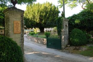 ein Tor zu einem Garten mit einem Steinzaun in der Unterkunft Belveyre à Rocamadour in Rocamadour