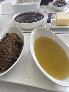 a white plate with bowls of soup and a bowl of food at Taybeh Golden Hotel in Ramallah