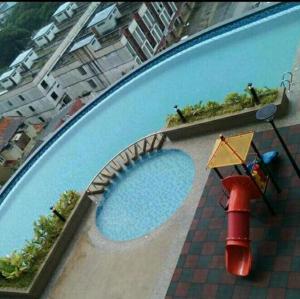 an overhead view of a swimming pool with a red object at Caliph Suite Apartment Homestay D'Perdana Sri Cemerlang Condominium Kota Bharu in Kota Bharu