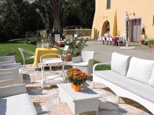 un patio con mobili bianchi, tavolo e sedie di Casale Fedele Family Relax B&B Vicino al Borgo a Ronciglione