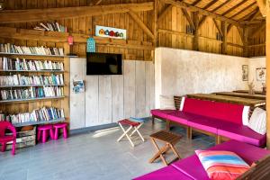 Zimmer mit einer roten Bank und Bücherregalen in der Unterkunft Camping Aux Couleurs du ferret in Lège-Cap-Ferret