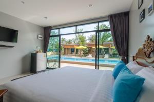 sypialnia z dużym łóżkiem i basenem w obiekcie Golf Inn Resort w mieście Samut Songkhram