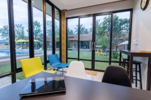 sala konferencyjna ze stołem, krzesłami i oknami w obiekcie Golf Inn Resort w mieście Samut Songkhram