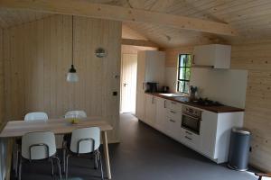 HavelteにあるMooi nieuw houten huisjeのキッチン(テーブル、椅子付)
