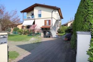 a house with a brick walkway in front of it at Appartamento Giona in Maccagno Superiore
