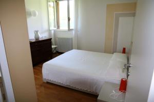 a bedroom with a white bed and a window at Appartamento Giona in Maccagno Superiore