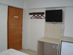 Habitación con TV en la pared y puerta en Hotel Litoral Fortaleza en Fortaleza