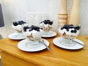 une table avec quatre bols de crème glacée et de myrtilles dans l'établissement Creagory Skye, à Portree