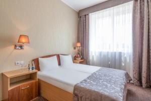 a bedroom with a large bed and a large window at Mariot Medical Center Hotel in Truskavets
