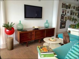 a living room with a flat screen tv on the wall at Penthouse over the sea in Sardina