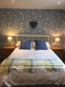 a bedroom with a large bed with blue pillows at Creagory Skye in Portree