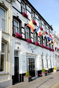 um edifício com bandeiras na lateral em Hotel Old Dutch Bergen op Zoom em Bergen op Zoom