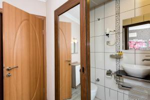 a bathroom with a sink and a toilet and a mirror at Olimpiyat Hotel Izmir in İzmir