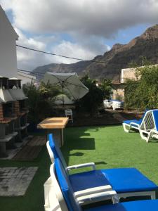 a patio with chairs and a table and an umbrella at Casa Elisa Canarias in Fátaga