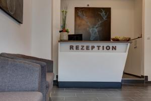 a reception desk in a living room with two chairs at INA Boutique 030 Hannover-City in Hannover