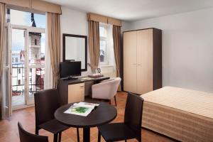 فندق براغا 1 في براغ: غرفة فندقية بسرير وطاولة وكراسي