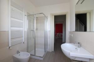 een witte badkamer met douche en wastafel bij Residenza Riva Azzurra in Rimini +36 foto's