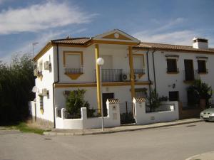 a white house with a fence in front of it at Casa La Vega in El Bosque