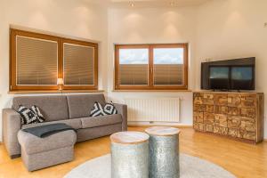 uma sala de estar com um sofá e uma televisão em Sportchalet Zillertal em Uderns