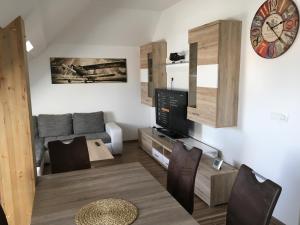 a living room with a couch and a clock on the wall at Apartments Avio in Zgornji Brnjik