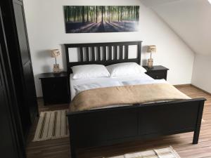 a bedroom with a large bed with two night stands at Apartments Avio in Zgornji Brnjik