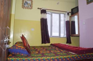 a bedroom with a bed and a window at Azure Family Paying Guest House in Varanasi