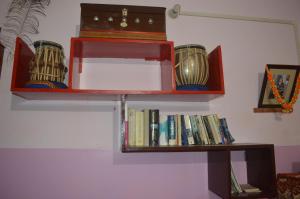 a shelf with books and a box on top of it at Azure Family Paying Guest House in Varanasi