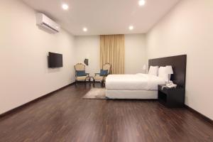 a hotel room with a bed and a table and chairs at Towlan Al Rawdah تولان للشقق المخدومة فرع الروضة in Riyadh