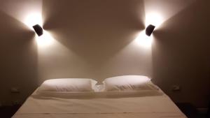 a bedroom with two lights on the wall and a bed at Giardino Labruto in Messina
