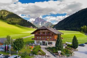 a large building in the middle of a mountain at Gasthof Tuscherhof in Braies