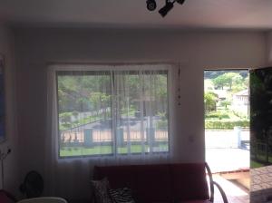 a living room with a window with a view of a yard at bei Mot - Apartamento de Férias in Pomerode