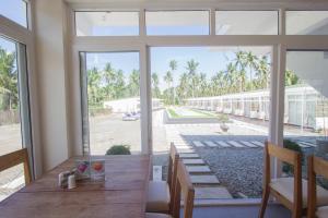 a dining room with a table and a large window at L'Sirene Boutique Resort in Baler