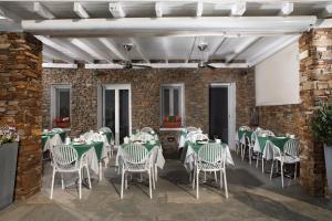 un comedor con mesas verdes y sillas blancas en Selana Suites, en Chrisopigi