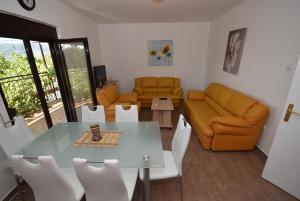 een woonkamer met een tafel en een bank bij Vila Loza in Herceg-Novi