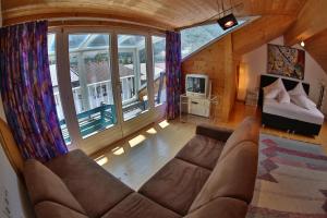 a living room with a couch and a bed and windows at Ferienhaus Moidl in Sölden