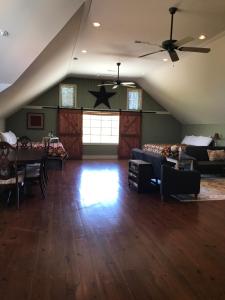 sala de estar con ventilador de techo y sofá en Hermann Barn House, en Hermann