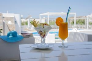 a table with two glasses of juice and a drink at Island House Hotel in Mylopotas