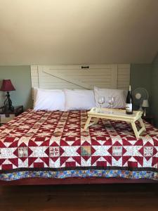 Una cama con una mesa con dos copas de vino. en Hermann Barn House, en Hermann