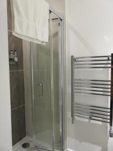 a shower with a glass door in a bathroom at The Cardinals Hat in Worcester