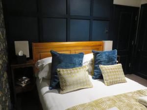 1 dormitorio con 1 cama con paredes y almohadas azules en The Cardinals Hat, en Worcester