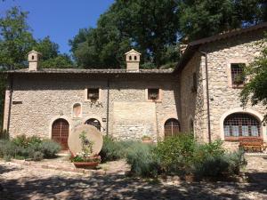 a stone house with a garden in front of it at Ancaiano Country House in Ferentillo