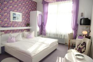 una camera da letto con un letto bianco e una finestra di HOTEL YOGA JASMIN ehemals Hotel Eberhardt-Burghardt a Badenweiler