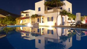 a house and its reflection in a pool at night at Brother's Hotel in Ios Chora