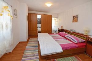 Schlafzimmer mit einem Bett mit rosa und weißer Bettwäsche in der Unterkunft Maja Apartment in Višnjan