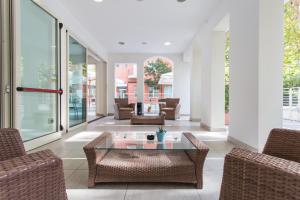 a living room with wicker chairs and a glass table at Wally Residence in Rimini