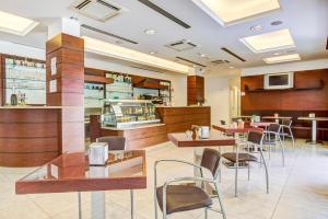 a restaurant with tables and chairs and a bar at Wally Residence in Rimini