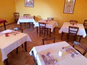 a restaurant with tables and chairs with white tablecloths at Agriturismo Casale Zuccari in Caprarola