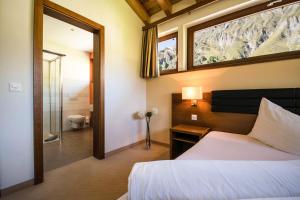 a bedroom with a bed and a window and a bathroom at Chasa Miramont in Samnaun